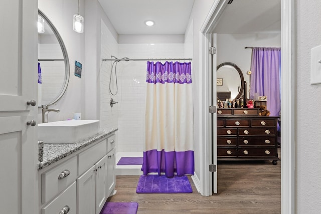 409 N Houston Ave, Denison, TX 75021 - full bath with tiled shower, wood finished floors, and vanity
