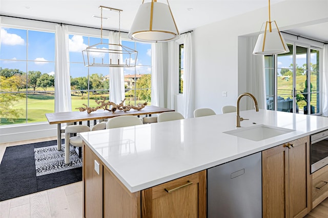 350 O Connor Ridge Blvd Unit 12, Irving, TX 75038 - kitchen with appliances with stainless steel finishes, view of golf course, light wood finished floors, light countertops, and hanging light fixtures