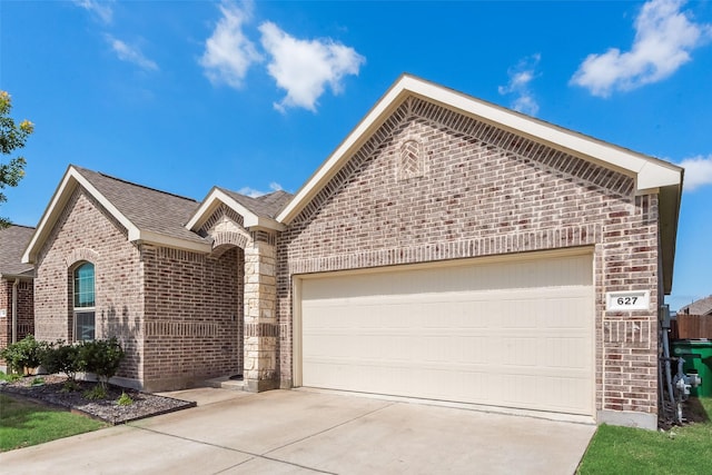 627 Beltrand Ln, Fate, TX 75087 - view of front facade featuring brick siding, concrete driveway, a garage, and a shingled roof
