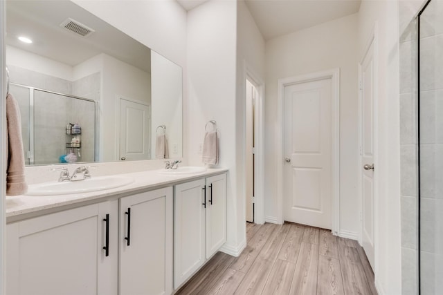 627 Beltrand Ln, Fate, TX 75087 - full bath with double vanity, a shower stall, and wood finished floors