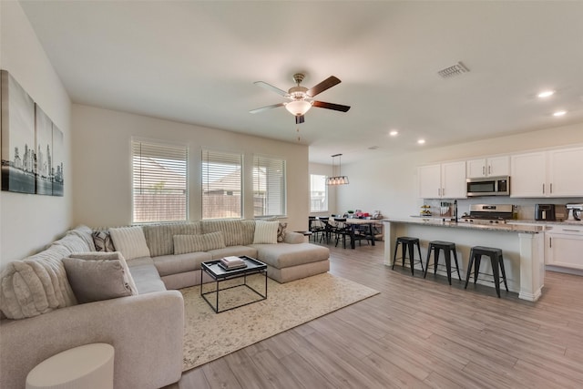 627 Beltrand Ln, Fate, TX 75087 - living room featuring a ceiling fan, recessed lighting, and light wood-style floors