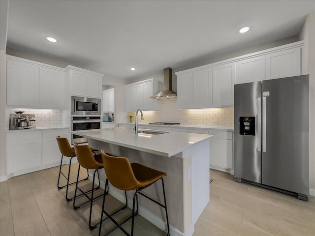 413 Coyote Creek Dr, Lavon, TX 75166 - kitchen featuring stainless steel appliances, wall chimney exhaust hood, backsplash, a center island with sink, and white cabinets