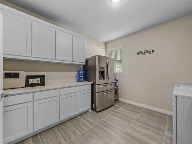 413 Coyote Creek Dr, Lavon, TX 75166 - kitchen with stainless steel fridge, washer / dryer, light countertops, and white cabinets