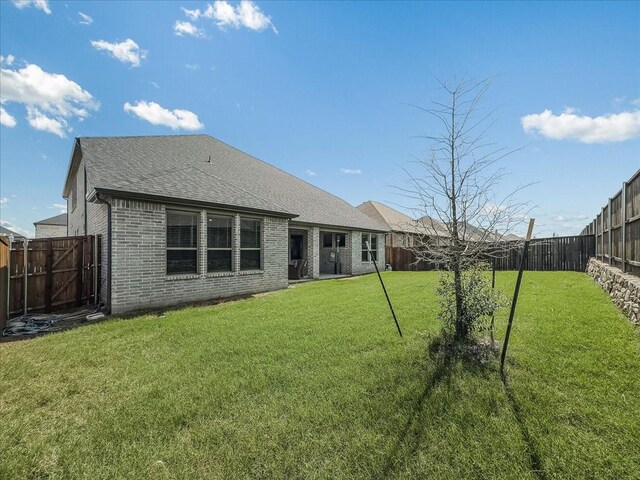 413 Coyote Creek Dr, Lavon, TX 75166 - back of house with brick siding, a fenced backyard, and a shingled roof