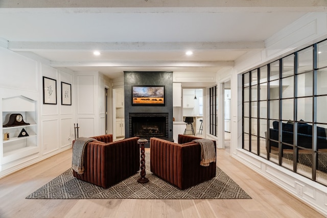 2304 Wakeforest Ct, Arlington, TX 76012 - living room with light wood-style flooring, beamed ceiling, a fireplace, a decorative wall, and built in features