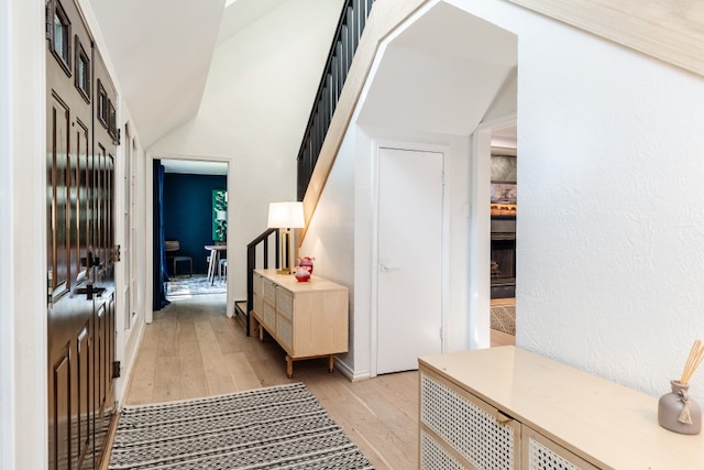 2304 Wakeforest Ct, Arlington, TX 76012 - hall featuring light wood-style flooring, stairway, and lofted ceiling