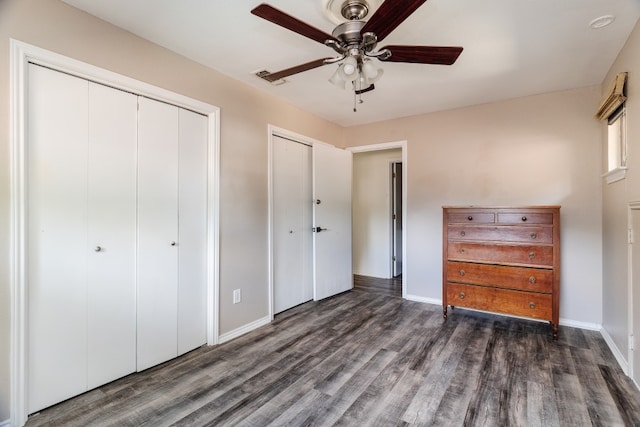 2304 Wakeforest Ct, Arlington, TX 76012 - unfurnished bedroom with dark wood-style flooring, a ceiling fan, and multiple closets