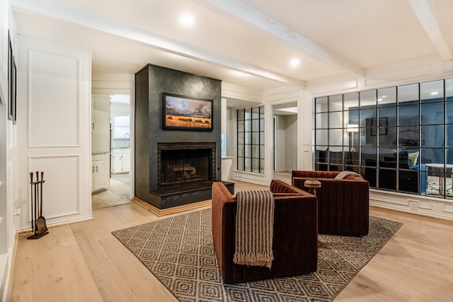 2304 Wakeforest Ct, Arlington, TX 76012 - living area with wood finished floors, a fireplace, beamed ceiling, and a decorative wall