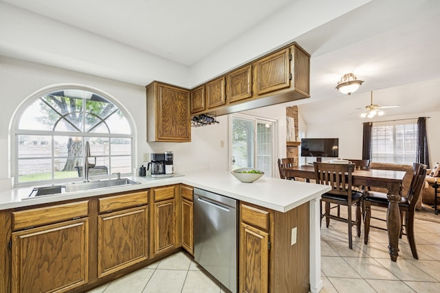 113 Windmill Ridge Dr, Rockwall, TX 75032 - kitchen featuring stainless steel dishwasher, light tile patterned floors, a peninsula, light countertops, and brown cabinetry