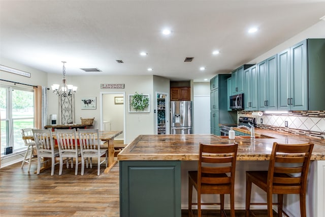 412 Paradise Canyon Cir, Paradise, TX 76073 - kitchen with stainless steel appliances, a chandelier, a peninsula, recessed lighting, and backsplash