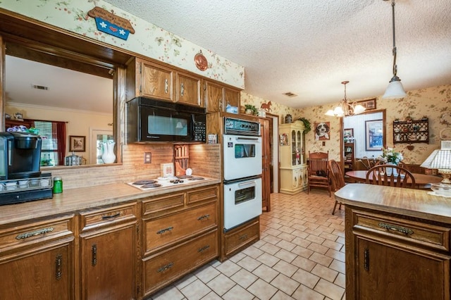 12869 Fm 1385, Pilot Point, TX 76258 - kitchen featuring wallpapered walls, white appliances, a chandelier, pendant lighting, and backsplash