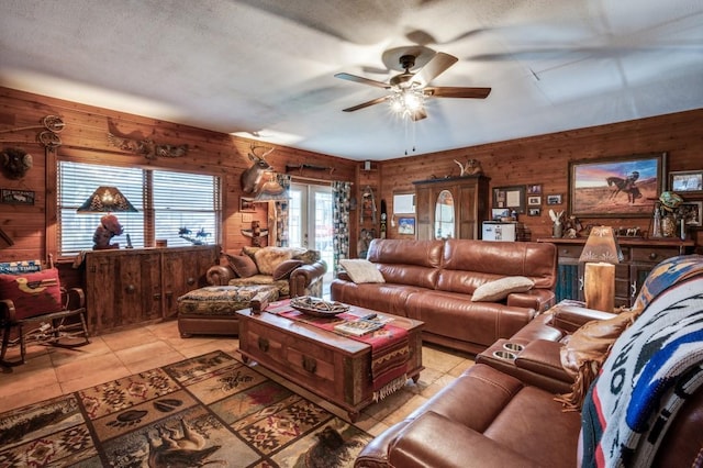 12869 Fm 1385, Pilot Point, TX 76258 - living room featuring wood walls, ceiling fan, and light tile patterned floors