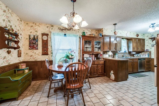 12869 Fm 1385, Pilot Point, TX 76258 - dining space with wallpapered walls, a wainscoted wall, healthy amount of natural light, a textured ceiling, and a chandelier
