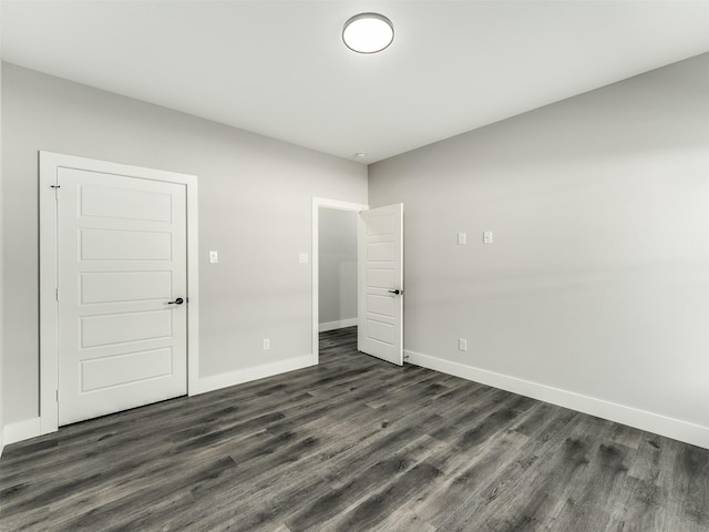2610 S Ewing Ave, Dallas, TX 75216 - unfurnished bedroom with baseboards and dark wood-style flooring