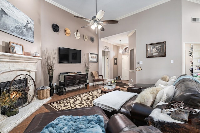 12953 Hurricane Ln, Fort Worth, TX 76244 - living room with crown molding, a ceiling fan, wood finished floors, and a warm lit fireplace
