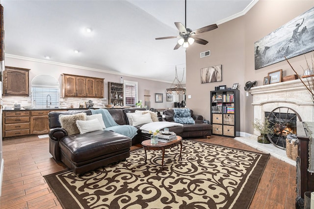 12953 Hurricane Ln, Fort Worth, TX 76244 - living room with ceiling fan, wood-type flooring, a warm lit fireplace, ornamental molding, and a chandelier