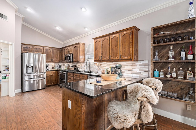 12953 Hurricane Ln, Fort Worth, TX 76244 - kitchen with stainless steel appliances, a peninsula, backsplash, dark stone counters, and vaulted ceiling