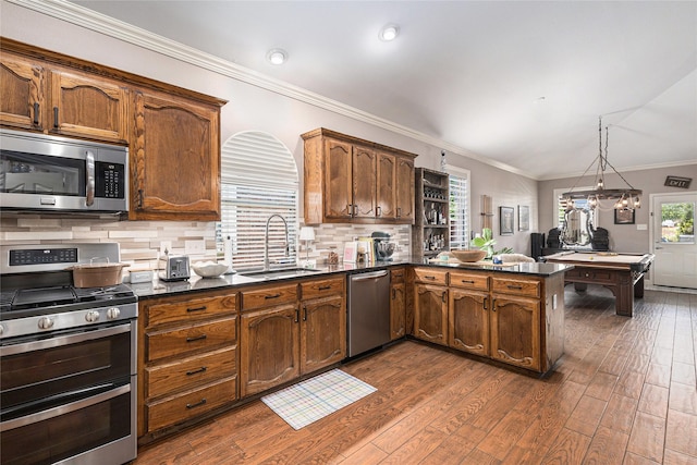 12953 Hurricane Ln, Fort Worth, TX 76244 - kitchen with stainless steel appliances, dark countertops, dark wood-style flooring, a peninsula, and decorative backsplash