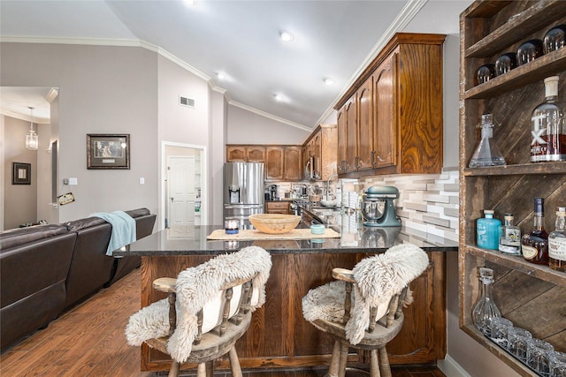 12953 Hurricane Ln, Fort Worth, TX 76244 - kitchen with stainless steel fridge with ice dispenser, a peninsula, vaulted ceiling, dark wood-style flooring, and backsplash
