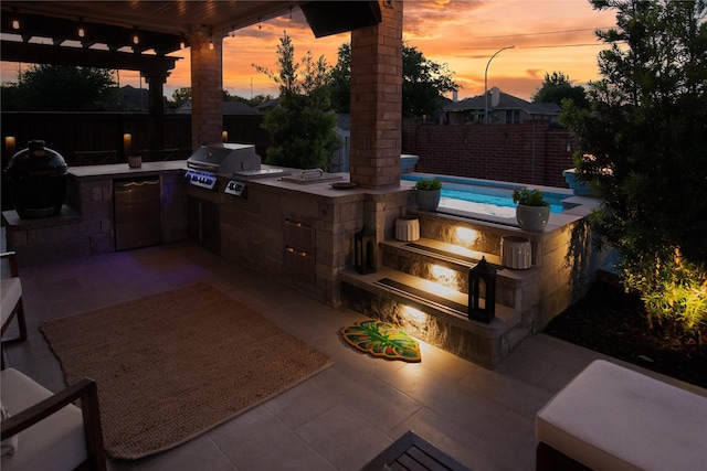 12953 Hurricane Ln, Fort Worth, TX 76244 - patio terrace at dusk with an outdoor kitchen, a fenced backyard, and a patio