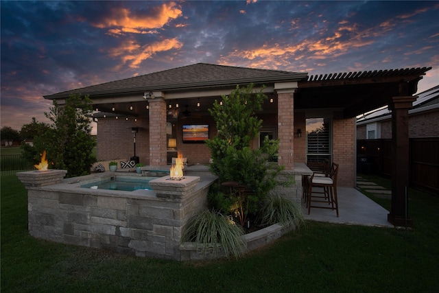 12953 Hurricane Ln, Fort Worth, TX 76244 - back of house at dusk with brick siding, a patio, and an outdoor fire pit