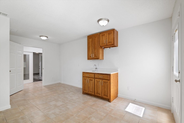 2206 Spring Leaf Dr, Carrollton, TX 75006 - kitchen with light countertops and brown cabinets