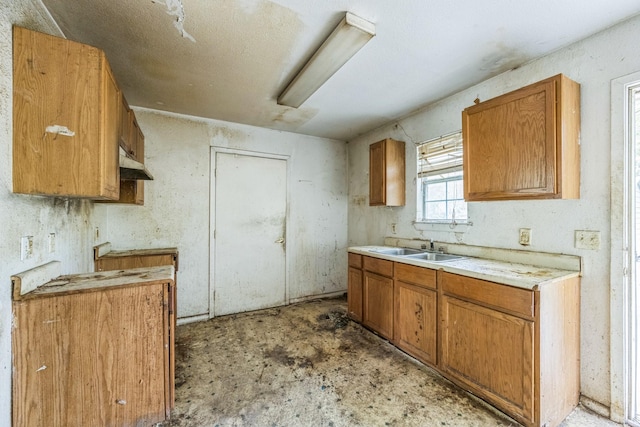 207 N 1st St, Crandall, TX 75114 - kitchen with light countertops, under cabinet range hood, and brown cabinets