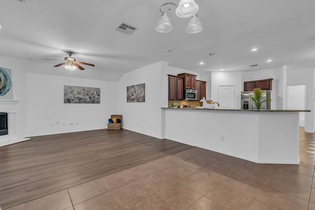 9700 Mulligan Dr, Mckinney, TX 75072 - unfurnished living room featuring a ceiling fan, tile patterned flooring, recessed lighting, and a fireplace with raised hearth