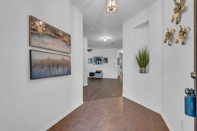 9700 Mulligan Dr, Mckinney, TX 75072 - hallway with dark tile patterned flooring and baseboards