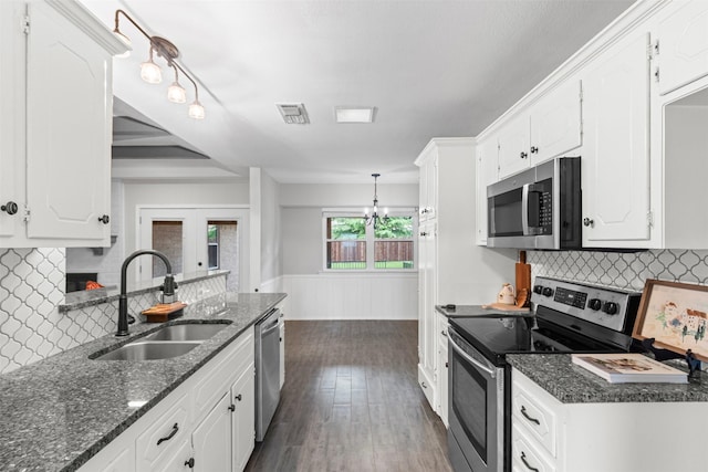 6767 Winifred Dr, Fort Worth, TX 76133 - kitchen with stainless steel appliances, white cabinetry, dark wood finished floors, tasteful backsplash, and wainscoting