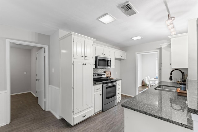 6767 Winifred Dr, Fort Worth, TX 76133 - kitchen with stainless steel appliances, white cabinetry, backsplash, wood finished floors, and dark stone counters