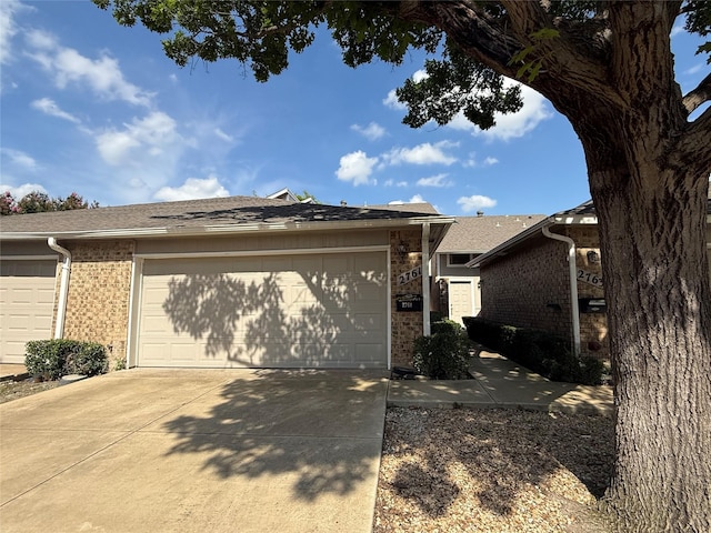2761 Stonecreek Dr, Carrollton, TX 75006 - view of front of home featuring brick siding, driveway, a garage, and a shingled roof
