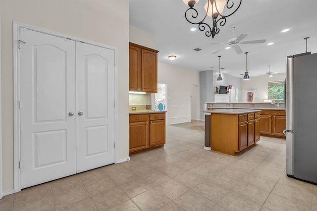 1651 Meadows Ave, Lantana, TX 76226 - kitchen featuring freestanding refrigerator, ceiling fan, light countertops, backsplash, and brown cabinets