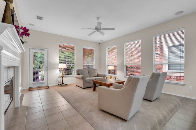 1651 Meadows Ave, Lantana, TX 76226 - living area featuring a ceiling fan, healthy amount of natural light, light tile patterned floors, and a glass covered fireplace