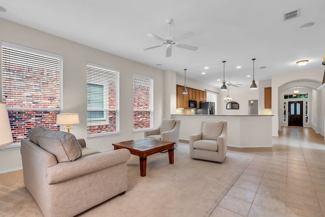 1651 Meadows Ave, Lantana, TX 76226 - living room featuring a ceiling fan, arched walkways, recessed lighting, light tile patterned floors, and light carpet