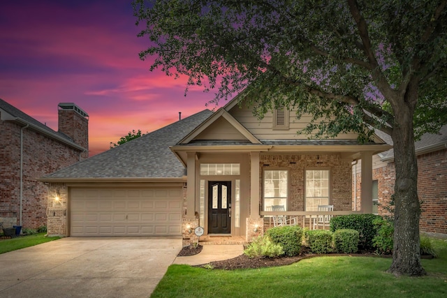 1651 Meadows Ave, Lantana, TX 76226 - view of front facade with an attached garage, concrete driveway, roof with shingles, covered porch, and brick siding