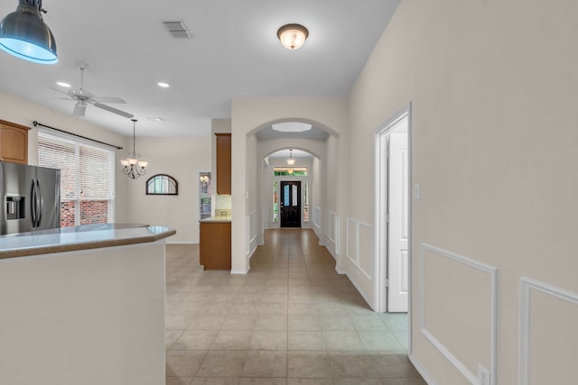 1651 Meadows Ave, Lantana, TX 76226 - kitchen with stainless steel refrigerator with ice dispenser, arched walkways, ceiling fan, light tile patterned floors, and hanging light fixtures