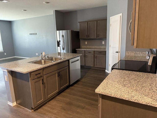 312 Wagon Wheel Dr, Josephine, TX 75189 - kitchen featuring appliances with stainless steel finishes, dark wood-style floors, a center island with sink, and light stone counters