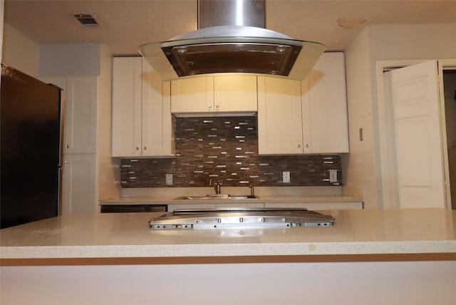 517 Annapolis Dr, Fort Worth, TX 76108 - kitchen with island range hood, freestanding refrigerator, backsplash, white cabinetry, and cooktop