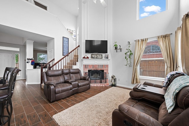 8534 Pebblebrook Dr, Frisco, TX 75034 - living room featuring a towering ceiling, a fireplace, dark wood finished floors, and stairs