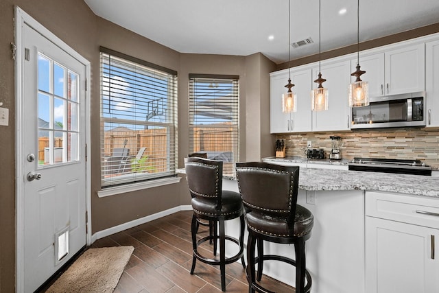 8534 Pebblebrook Dr, Frisco, TX 75034 - kitchen featuring stainless steel appliances, decorative backsplash, white cabinets, plenty of natural light, and recessed lighting