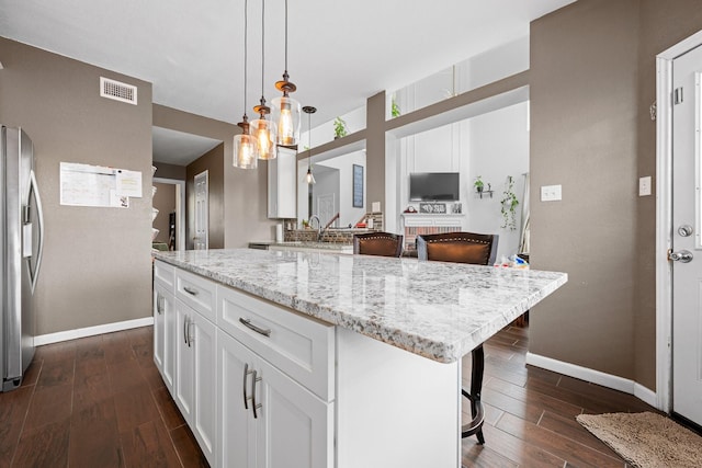 8534 Pebblebrook Dr, Frisco, TX 75034 - kitchen with stainless steel fridge with ice dispenser, dark wood finished floors, white cabinetry, and light stone countertops