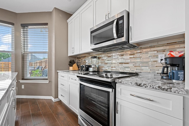 8534 Pebblebrook Dr, Frisco, TX 75034 - kitchen featuring appliances with stainless steel finishes, backsplash, light stone countertops, and white cabinetry