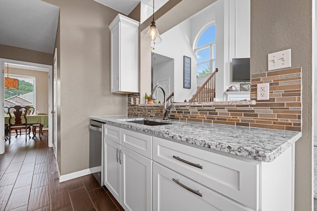 8534 Pebblebrook Dr, Frisco, TX 75034 - kitchen featuring healthy amount of natural light, tasteful backsplash, dishwasher, white cabinets, and a textured wall