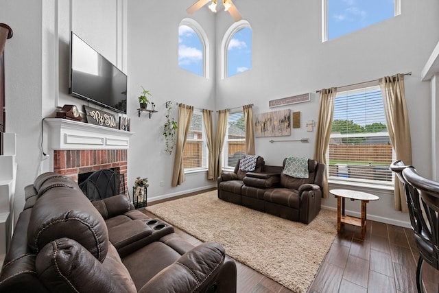8534 Pebblebrook Dr, Frisco, TX 75034 - living room featuring a high ceiling, ceiling fan, a fireplace, and dark wood-style floors
