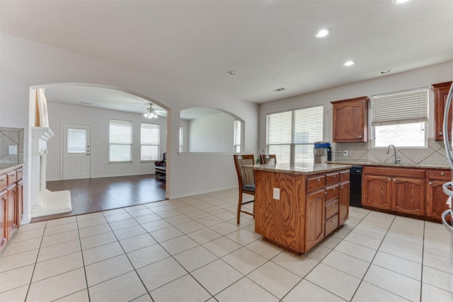 511 Poplar Vista Ln, Arlington, TX 76002 - kitchen featuring light tile patterned flooring, arched walkways, a ceiling fan, recessed lighting, and a breakfast bar