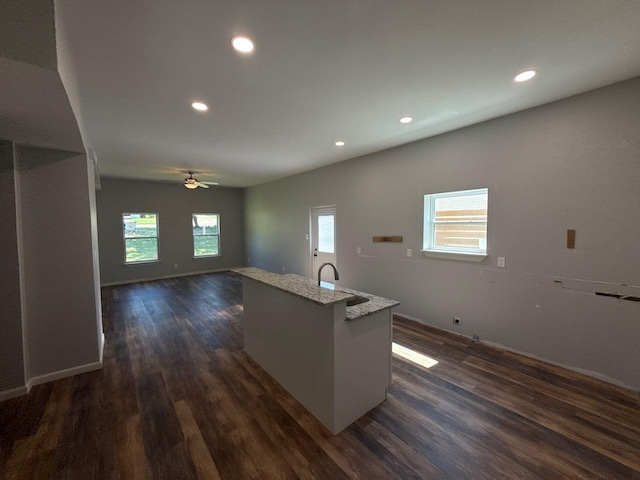 1510 W Woodard St, Denison, TX 75020 - kitchen featuring dark wood-type flooring, recessed lighting, ceiling fan, a kitchen island with sink, and light stone countertops