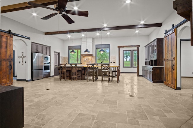 101 Goldfinch Ln, Weatherford, TX 76088 - kitchen featuring a barn door, stainless steel appliances, backsplash, a breakfast bar, and recessed lighting