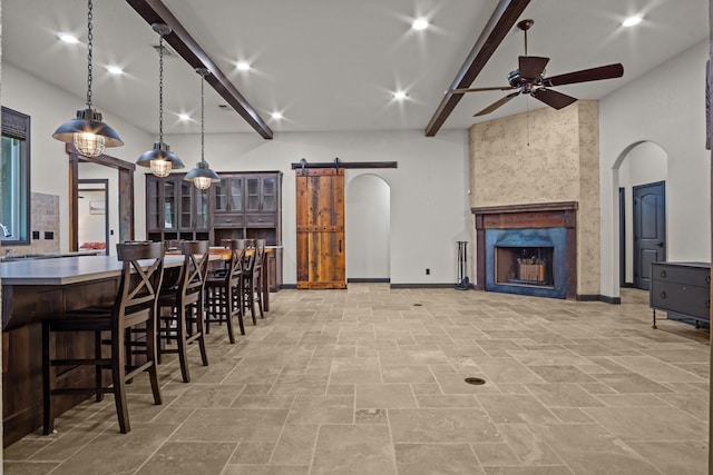 101 Goldfinch Ln, Weatherford, TX 76088 - kitchen with a barn door, a ceiling fan, beam ceiling, stone tile flooring, and arched walkways