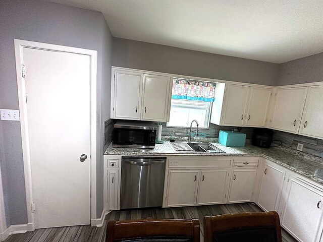 1325 W Chestnut St, Denison, TX 75020 - kitchen featuring stainless steel appliances, dark wood-style flooring, white cabinets, light countertops, and backsplash